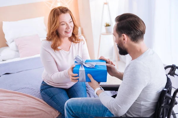 woman and a disabled man holding a present