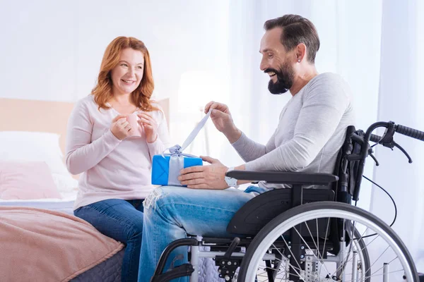 Happy handicapped man opening a gift