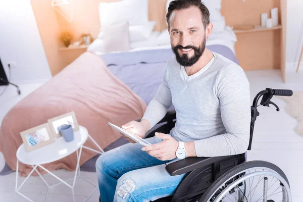 Homem deficiente sorrindo usando um tablet — Fotografia de Stock