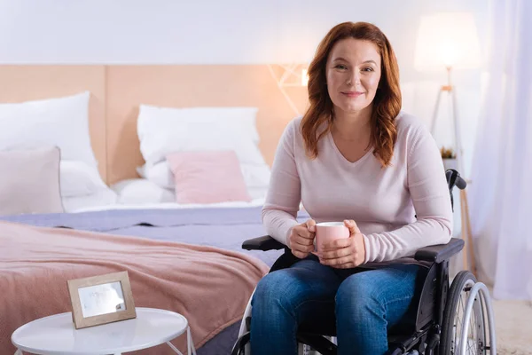 Mujer discapacitada sonriente sosteniendo una taza — Foto de Stock