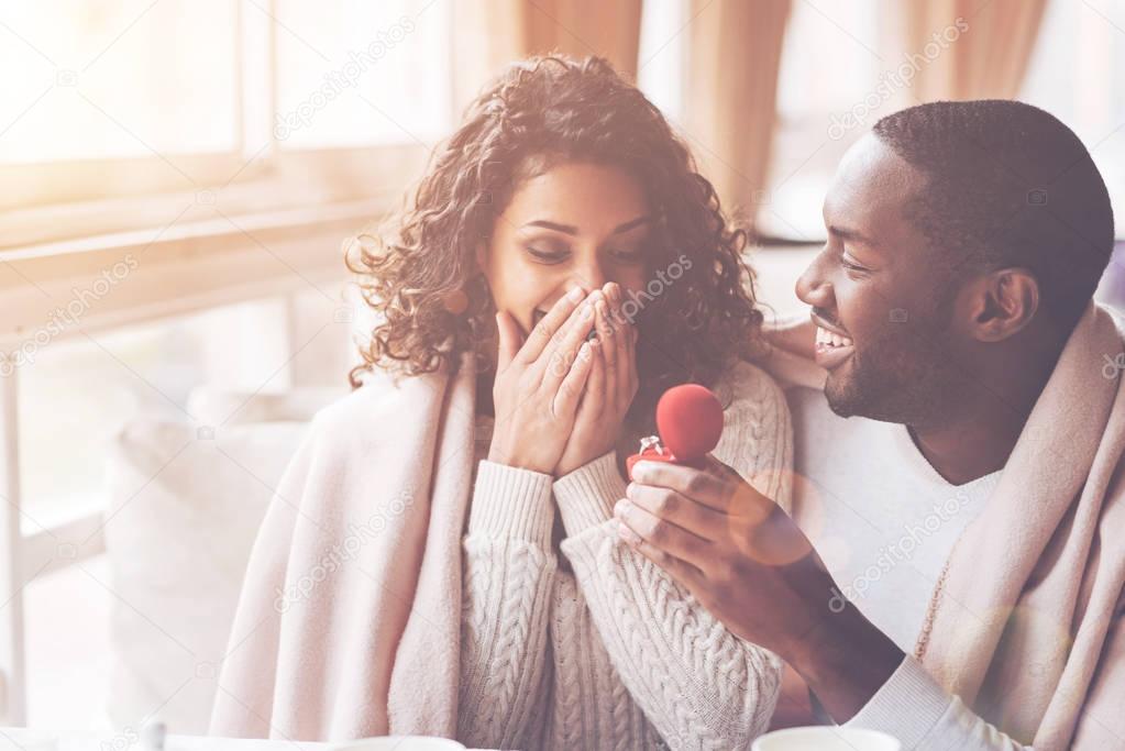 Happy black man giving ring to his bride