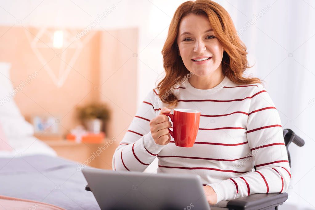 handicapped woman with her laptop and a cup