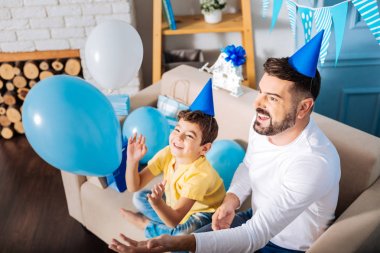 Baba oğul balonlarla oynuyorlar. 