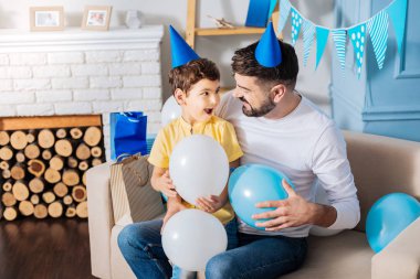 Baba ve oğul balonlar tutarak ve söz