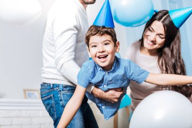 Küçük çocuk anne babasıyla oynarken gülüyor