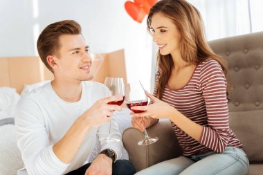 Evde şarap kırmızı içme gülen genç Çift