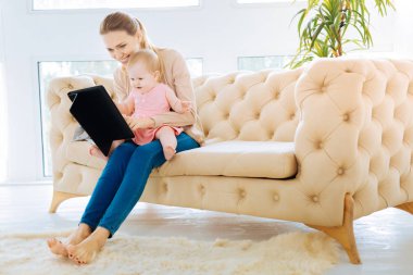 Bir tablet ekranına bakarak mutlu bebek