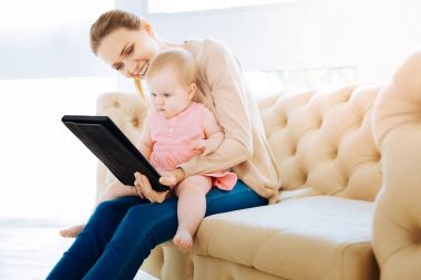 Bir tablet ekranına bakarak konsantre özenli bebek