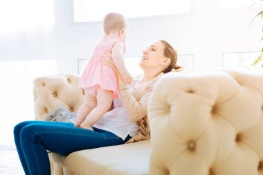 Küçük bir çocuk ile oynarken mutlu anne