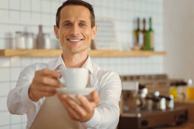 Bir fincan kahve sunan mutlu neşeli adam