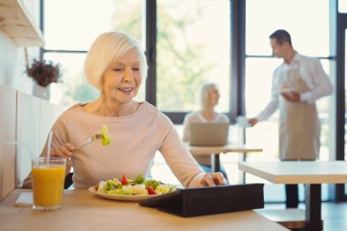 Neşeli yaşlı kadın tablet kullanma
