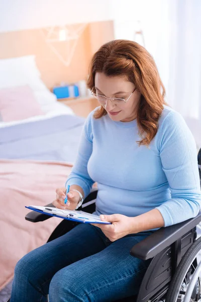 Mujer discapacitada escribiendo y usando gafas — Foto de Stock