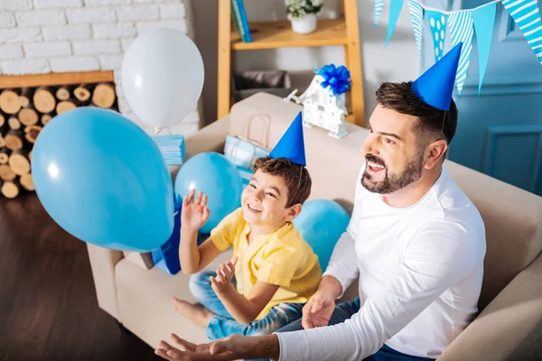 Baba oğul balonlarla oynuyorlar. 
