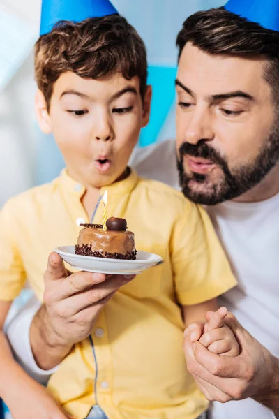 Padre ayudando a su hijo a soplar vela en la torta —  Fotos de Stock
