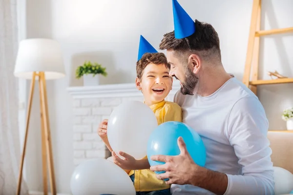 Hijo y padre riendo mientras sostiene globos —  Fotos de Stock