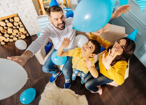 Familia alegre lanzando globos — Foto de Stock