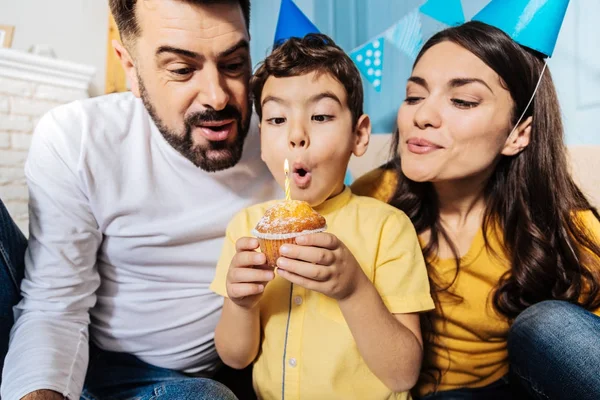 Familia feliz soplando vela —  Fotos de Stock