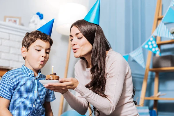 Pequeño niño y su madre soplando vela de cumpleaños —  Fotos de Stock