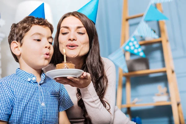 Feliz madre e hijo soplando vela en la torta juntos —  Fotos de Stock