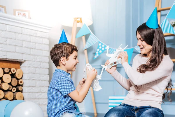 Vrolijke zoon en moeder vechten met speelgoed robots — Stockfoto