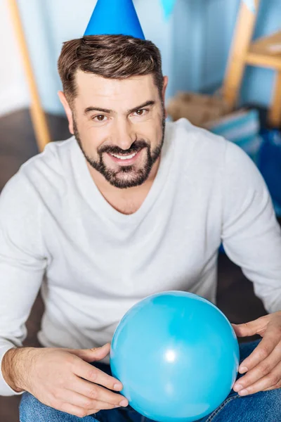 Trevlig ung man poserar med en blå ballong — Stockfoto