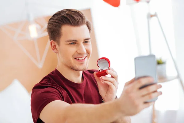 Radiant man taking selfies with proposal ring — Stock Photo, Image