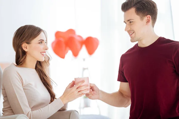 Mindful guy bringing cup of tea for girlfriend — Stock Photo, Image