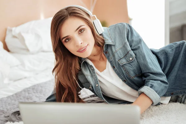 Jovencita inteligente en auriculares trabajando en el ordenador portátil — Foto de Stock