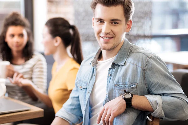 Freudiger Mann lächelt und sitzt am Tisch — Stockfoto