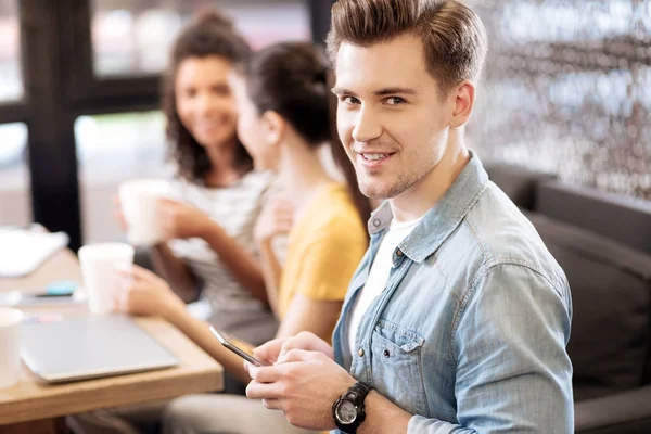 Smiling young man using his phone — Stock Photo, Image