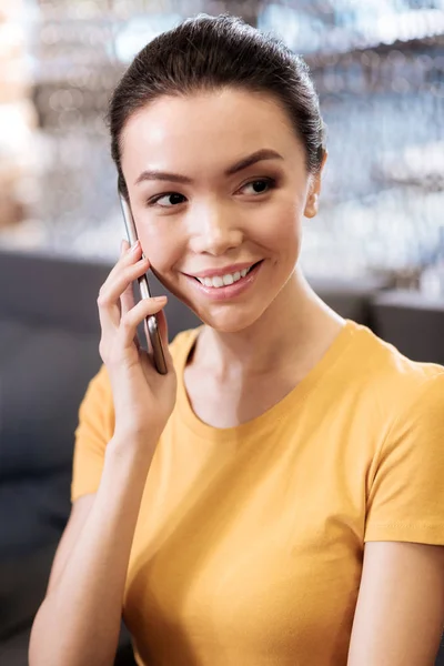 Радісна дівчина посміхається і розмовляє по телефону — стокове фото