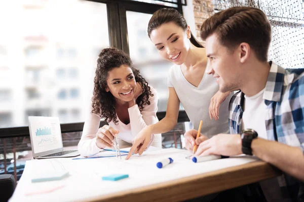 Inspirierter Mann und zwei Damen, die eine technische Zeichnung machen — Stockfoto