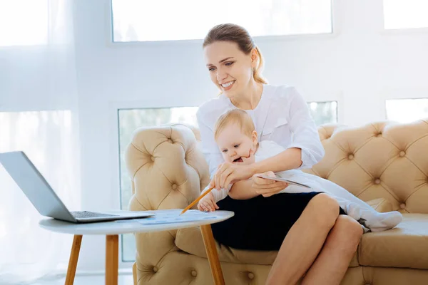 Cheerful busy woman with a child looking excited — Stock Photo, Image