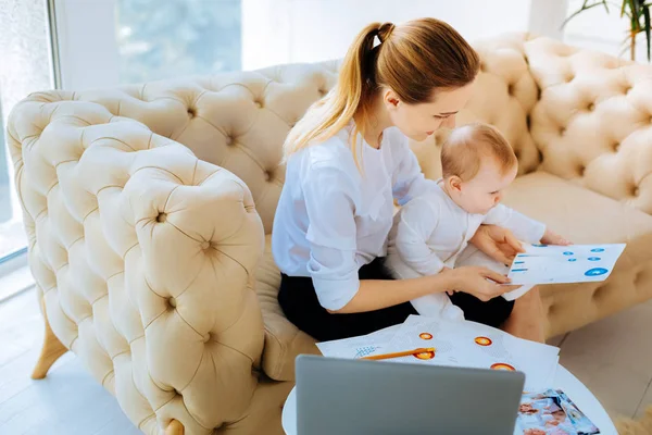 Amable mujer de negocios mostrando diagramas brillantes a un niño curioso — Foto de Stock