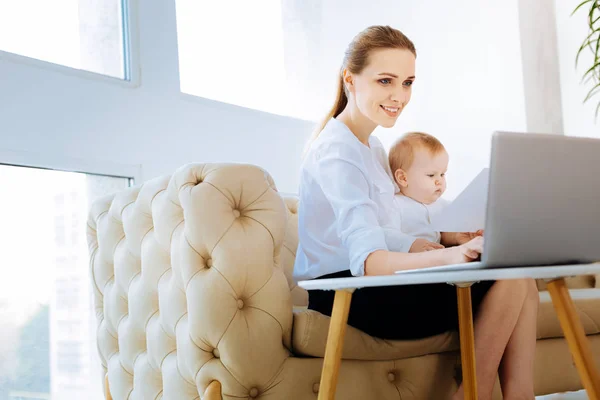 Vrolijke moeder blij zoeken terwijl u werkt thuis — Stockfoto