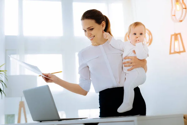 Cheerful young woman with a cute baby in her arms — Stock Photo, Image