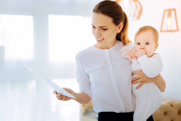 Cheerful young mother looking at her documents — Stock Photo, Image