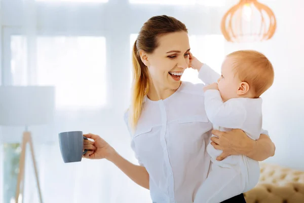 Positive mother drinking tea with her child — Stock Photo, Image
