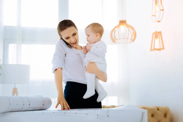 Happy working mother talking on the phone — Stock Photo, Image