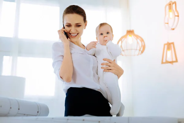 Boldog fiatal anya tárgyaláson kellemes szöveg-ra-a telefon — Stock Fotó