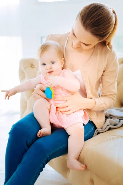 Positivo giovane donna seduta a giocare con un bambino piccolo — Foto Stock