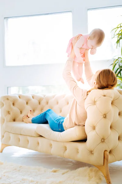 Oynak anne çocuğunu kucağında yüksek tutan — Stok fotoğraf