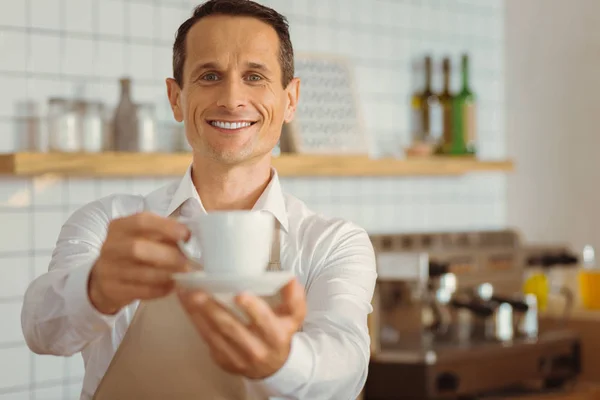 Feliz homem alegre oferecendo-lhe uma xícara de café — Fotografia de Stock