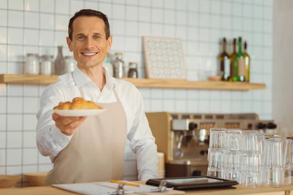 Potěšen pozitivní muž nabízí croissanty — Stock fotografie