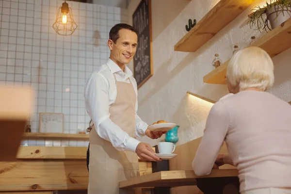 Happy positive waiter looking at his customer — Stock Photo, Image