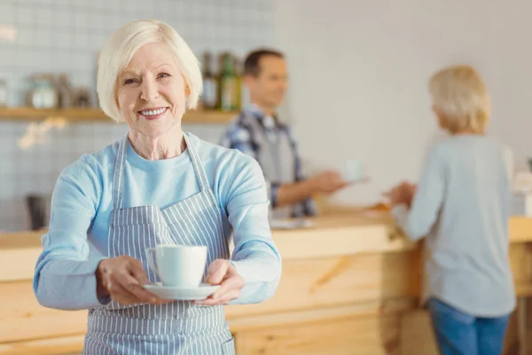 Lycklig glad kvinna erbjuder dig en kopp kaffe — Stockfoto