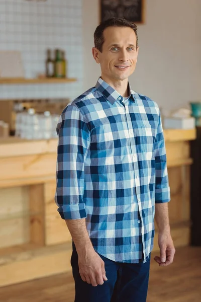 Pleasant good looking man standing in the kitchen