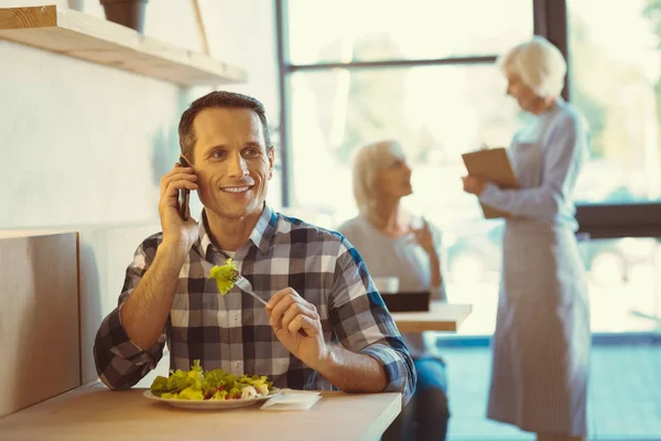 Guapo hombre positivo comiendo una ensalada —  Fotos de Stock