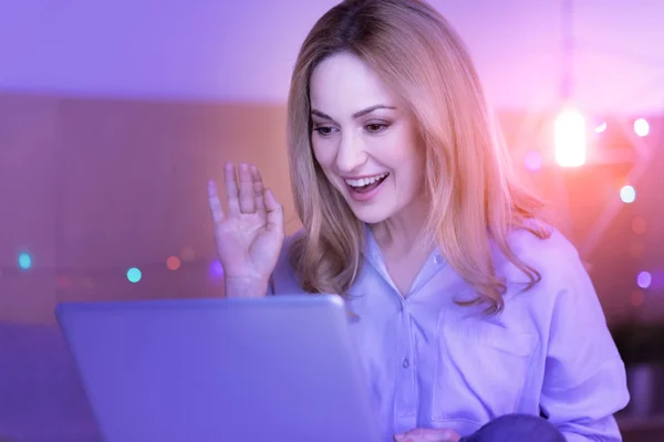 Lycklig lady viftande på cam av hennes laptop — Stockfoto