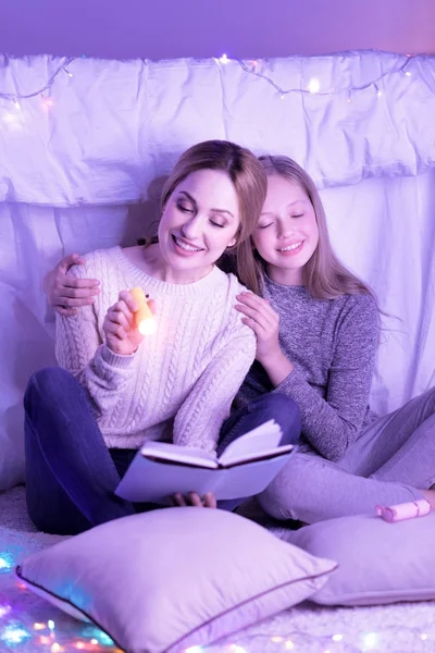 Kochającą matkę i córkę tulenie podczas czytania — Zdjęcie stockowe